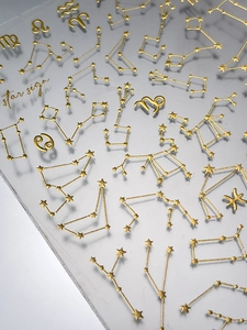 Detailed close-up of 3D gold embossed zodiac nail stickers with celestial star signs