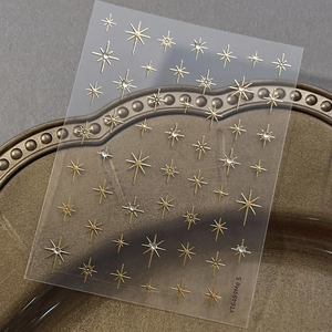 Gold glitter star nail art stickers with crystal accents and various stellar patterns