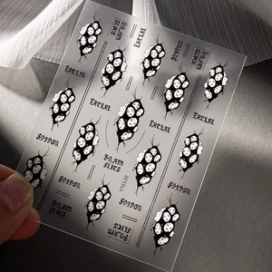 Gothic Halloween nail stickers with spiders and facial patterns on dark textured surface