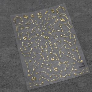 Gold zodiac nail art stickers featuring constellations and stars on a matte gray base