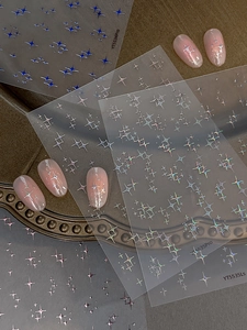 Close-up of holographic silver star nail art stickers and finished nail tips