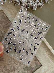 Détail de stickers nail art floraux aux motifs de pétales noirs et argentés style rétro