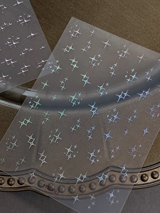 Close-up of laser holographic star nail art stickers with iridescent sparkle effect