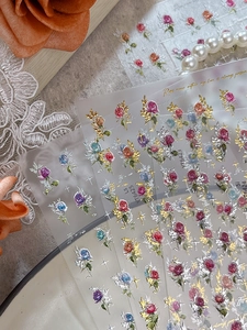 Macro detail of 3D embossed rose nail stickers with elegant pearls and lace texture