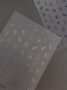 Macro detail of metallic silver and blue sparkle cross star nail art stickers on film