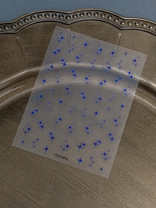 Detailed view of laser blue star nail art stickers on a metallic tray, model YT5534Pro