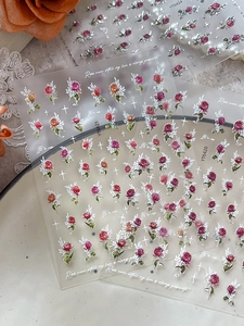 Detailed macro shot of vintage floral rose nail art stickers with elegant lace and pearls