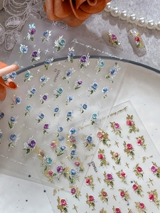 Detail of 3D embossed rose nail stickers with colorful flowers and golden stars