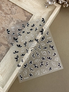 Vue macro d'autocollants pour ongles à pétales noir et argent avec bordures métalliques