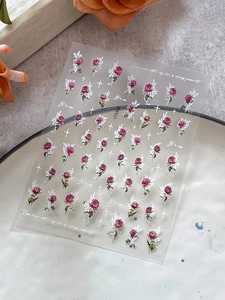 Detail of YT6420 3D rose nail stickers with red floral patterns and script on ceramic plate
