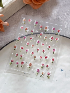 Detail shot of relief rose nail stickers with floral patterns and script elements