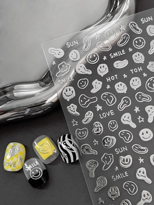 Close-up of 3D embossed silver smiling face and text nail art stickers on various nails
