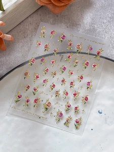 Close-up of 3D embossed rose nail stickers with gold glitter and French vintage patterns