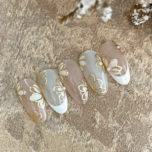 Stickers à ongles dorés en rose nude et bleu avec motifs floraux et accents de perles