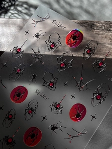 Macro shot of silver laser spider and web nail stickers on a wooden surface