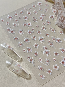 Détail des stickers ongles 3D en relief fleurs de plâtre avec accents roses et perles