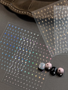 Detailed holographic and gold star nail art stickers on gradient manicured nails