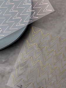 Detailed view of rose gold and gold geometric V-line nail art stickers with metallic finish