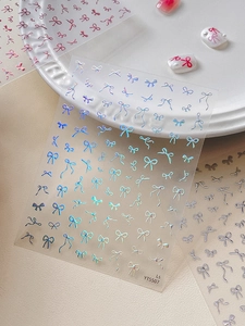 Detail of laser holographic bow nail stickers with pearls and professional finish