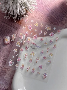 Detail of Christmas nail stickers with gold and pink festive ice cream and snowflake patterns