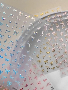 Detailed view of 3D bow nail art stickers with metallic laser silver and gold finish