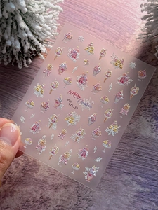 Detailed view of 3D embossed Christmas nail stickers featuring ice cream and star patterns