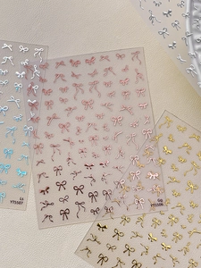 Detailed view of 3D metallic bow nail art stickers in gold, silver and rose gold