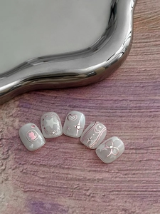 Detail of press-on nails with rose gold bow, cat silhouette and shiny rhinestones