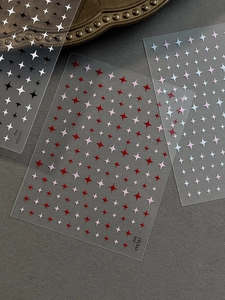 Detail of star-shaped nail art stickers in various colors on matte background