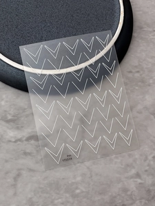 Macro detail of French style nail stickers featuring white double V-line geometric patterns