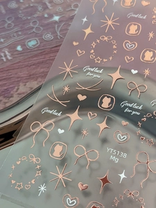 Macro view of rose gold bow, heart, and star nail art stickers with metallic finish