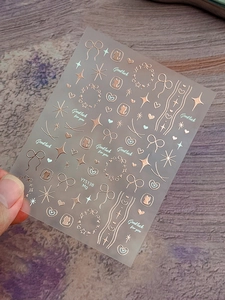 Detailed view of rose gold bow, heart and cat nail stickers with metallic finish