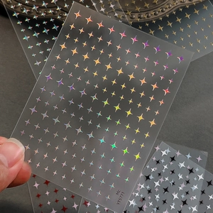 Minimalist holographic star nail stickers with laser aurora sparkle effect on grey background