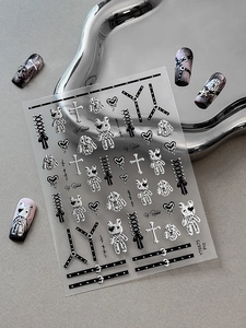 Macro shot of silver gothic rabbit and heart nail art stickers on display nails