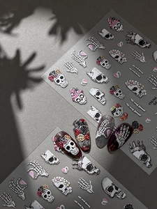 Adesivi per unghie Halloween 3D con teschi, ossa e rose su sfondo grigio testurizzato