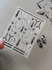 Macro view of silver gothic nail stickers featuring punk rabbits and hearts patterns