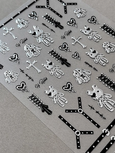Detailed macro view of 3D gothic silver heart and rabbit nail stickers with relief texture