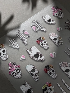 Vista macro dettagliata degli adesivi 3D per unghie di Halloween con teschi e cuori