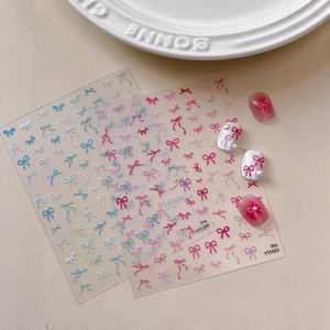 Flat bow nail stickers set with pink and blue ribbons and pearl accents on white background