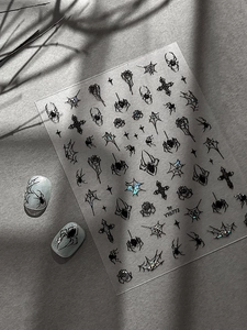 Dettagli di adesivi nail art gotici per Halloween con ragni e rose su sfondo grigio chiaro