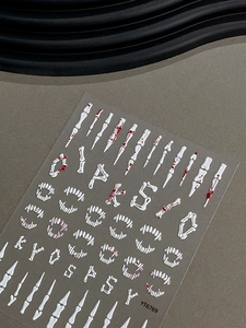 Macro detail of 3D embossed Halloween nail stickers with white bones and blood splashes