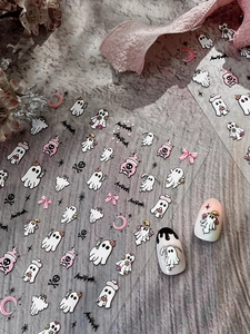 Detailed view of 3D Halloween ghost and bat nail stickers on stone background with props