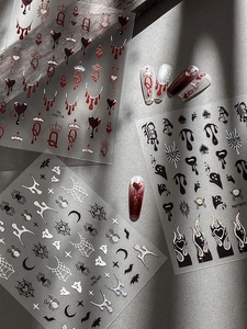 Detail of Halloween nail stickers with silver spider webs and black flame heart designs