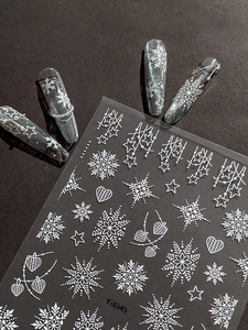 Close-up of 5D white embossed Christmas snowflake nail stickers with texture