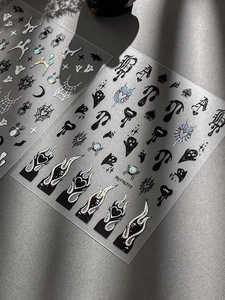 Macro detail of Halloween nail stickers with holographic spiders and gothic flame designs