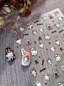 Detail of Halloween nail art stickers with ghosts and bats on checkered and gradient nails