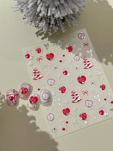 Détail d'autocollants 3D pour ongles de Noël avec cœurs rouges et nœuds argentés
