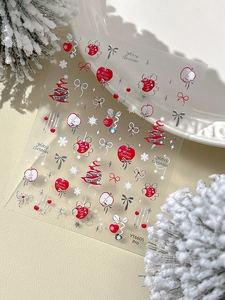 Gros plan de stickers à ongles de Noël avec pommes rouges et nœuds argentés