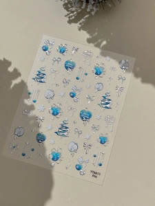 Détail macro d'autocollants de Noël argentés pour ongles avec motifs sapin et flocons