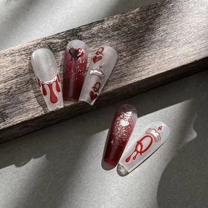 Gothic dark style press-on nails featuring red glitter tips, heart and crown designs